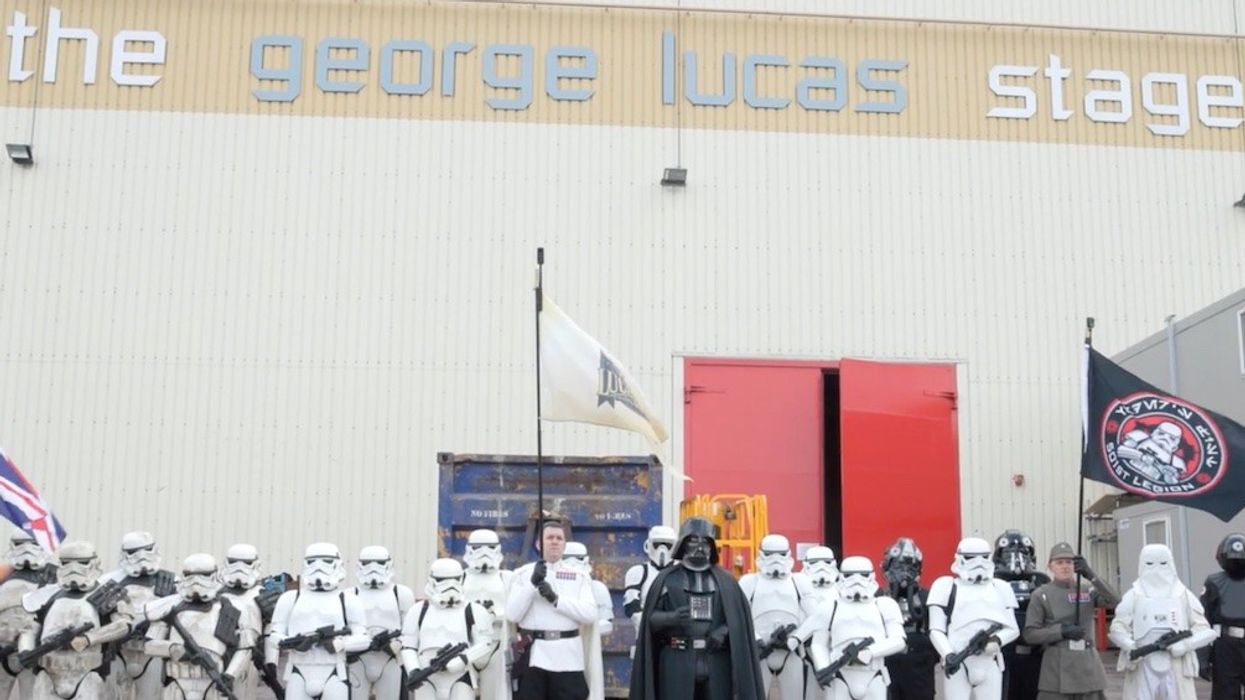 Group in Star Wars costumes outside the George Lucas stage, holding flags.