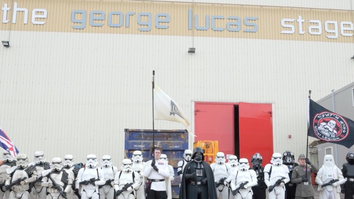 Group in Star Wars costumes outside the George Lucas stage, holding flags.