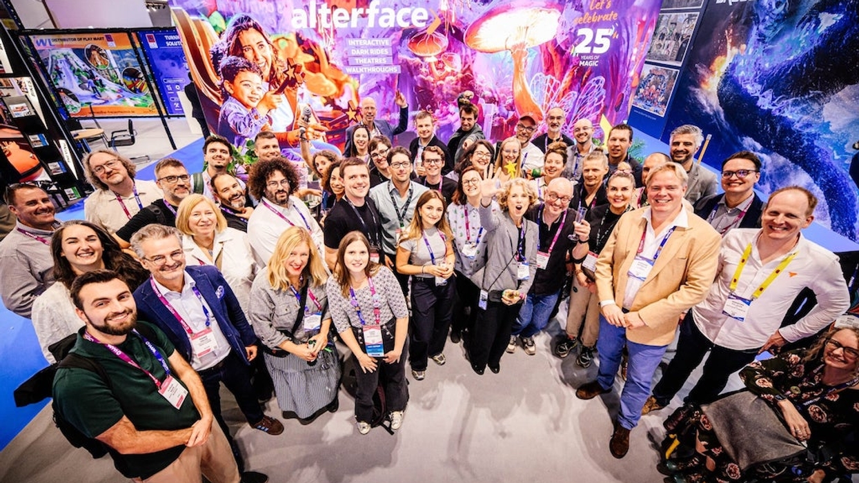 Group of diverse people smiling at a colorful event booth, celebrating Alterface's 25th anniversary together.