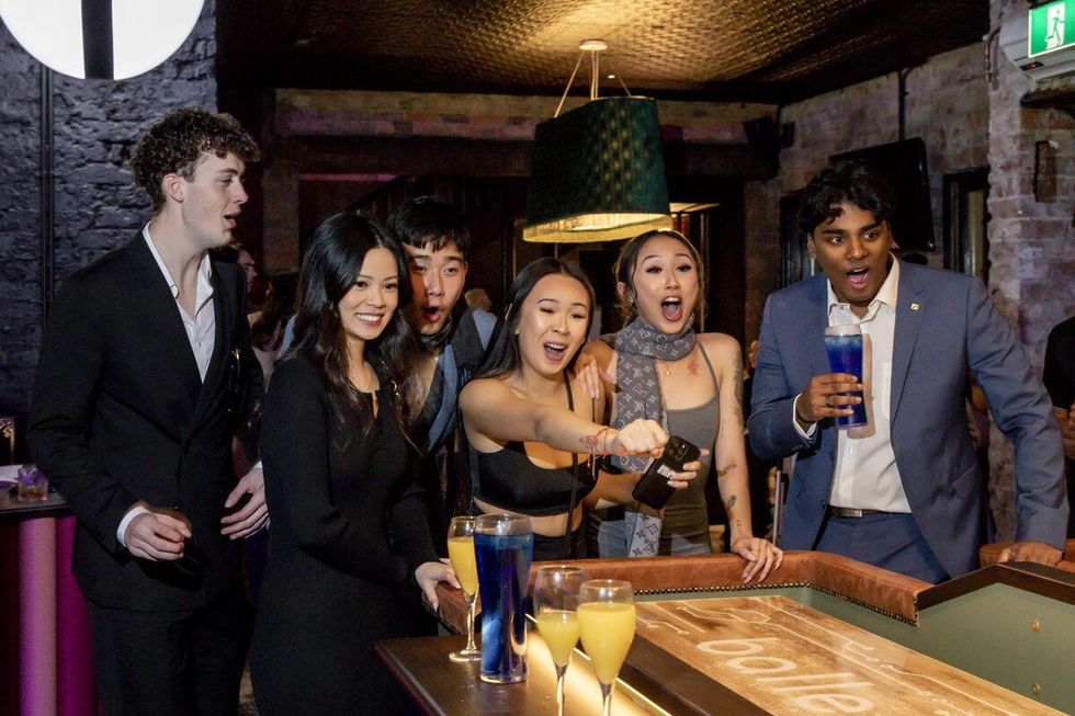 Group of friends excitedly watching a game at a casino table.