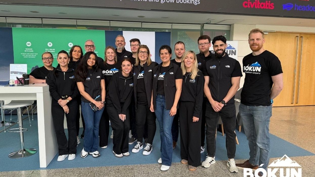 Group of people in matching shirts at a Bókun event booth indoors.