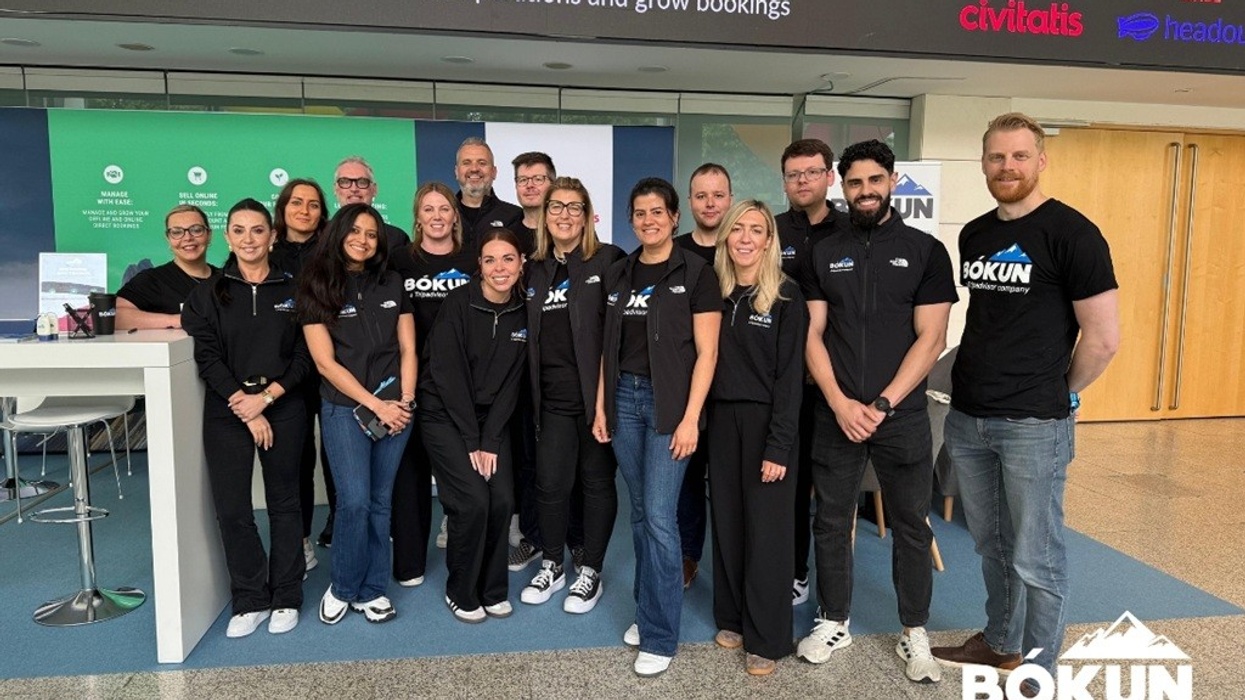 Group of people in matching shirts at a Bókun event booth indoors.