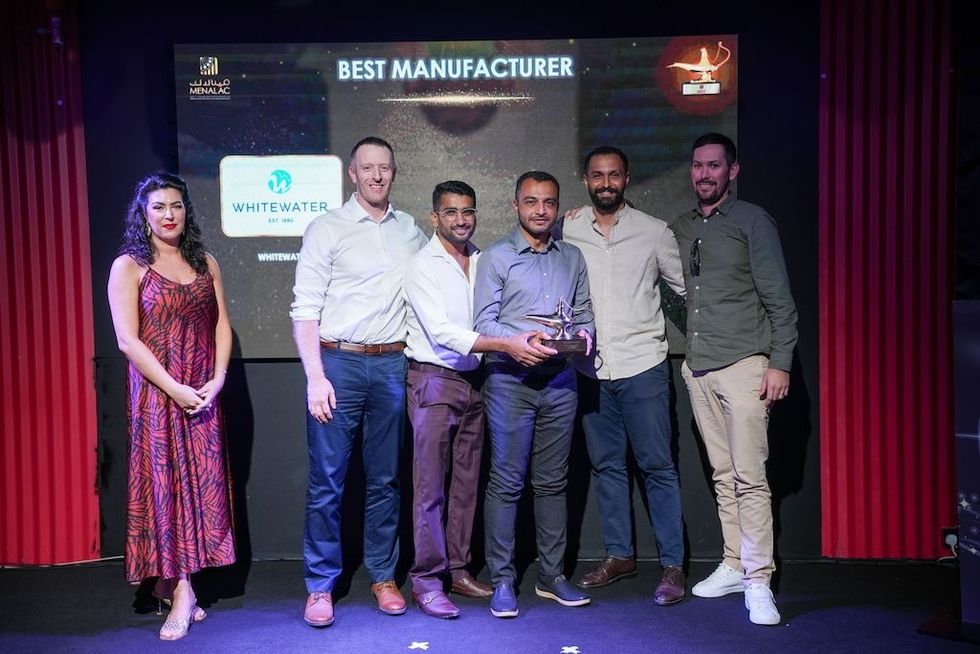 Group of six WhiteWater team members smiling, holding a "Best Manufacturer" award on stage at MENALAC Awards 2026