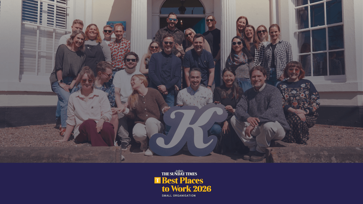 Group of smiling people posing outdoors with a large "Katapult" sign in front of a building, with text reading The Sunday Times Best Places to Work 2026
