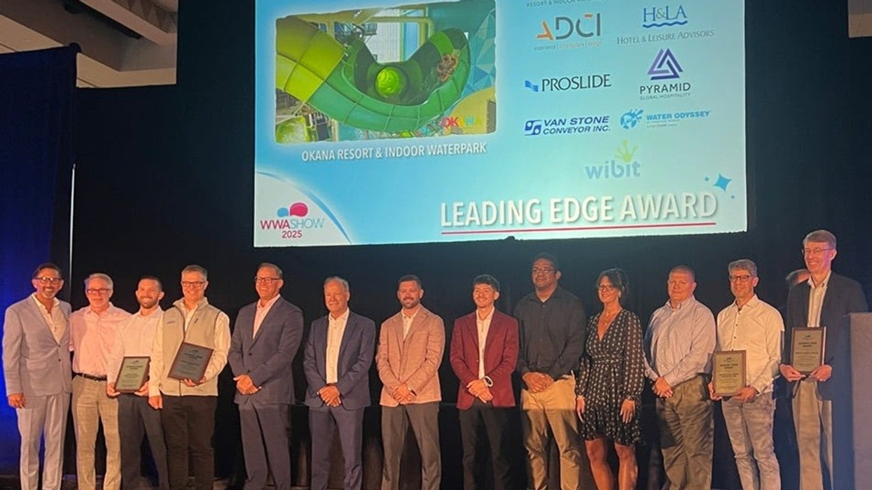 Group on stage with awards in front of "Leading Edge Award" screen display.