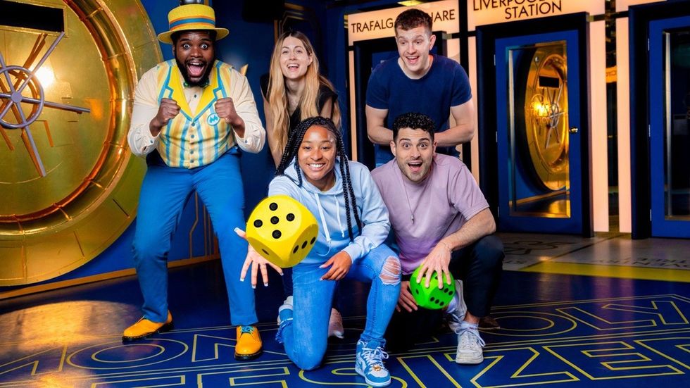 Group posing with oversized dice in a game-themed setting.