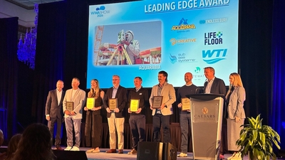 Group receiving Leading Edge Award on stage with blue-lit background.