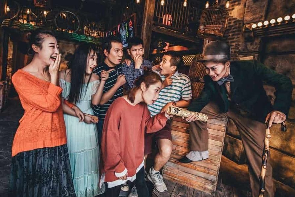 Guests being entertained by actor with walking stick at The Shanghai Dungeon