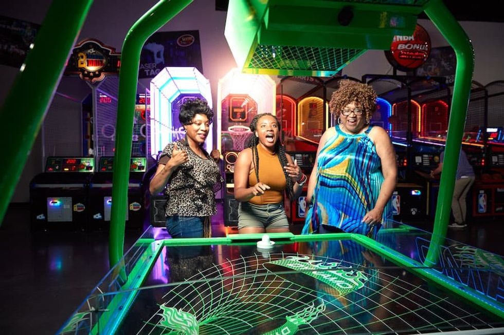 guests playing air hockey at a Scene75 FEC