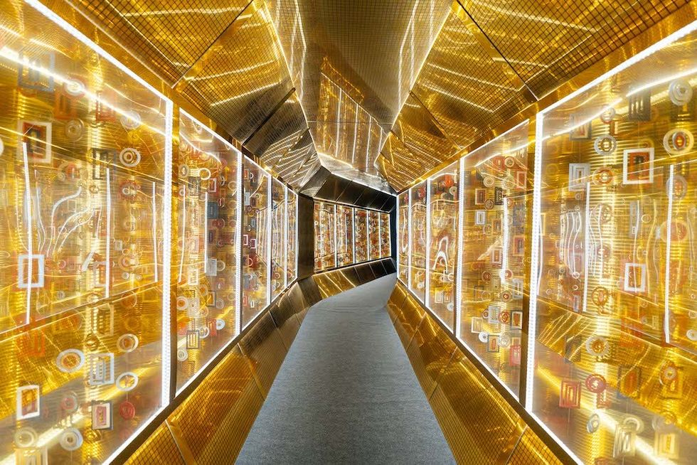 Gustav Klimt: The Immersive Experience- futuristic corridor with glowing golden panels and abstract patterns.