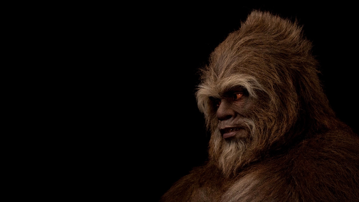 Hairy humanoid creature with glowing eyes in darkness.