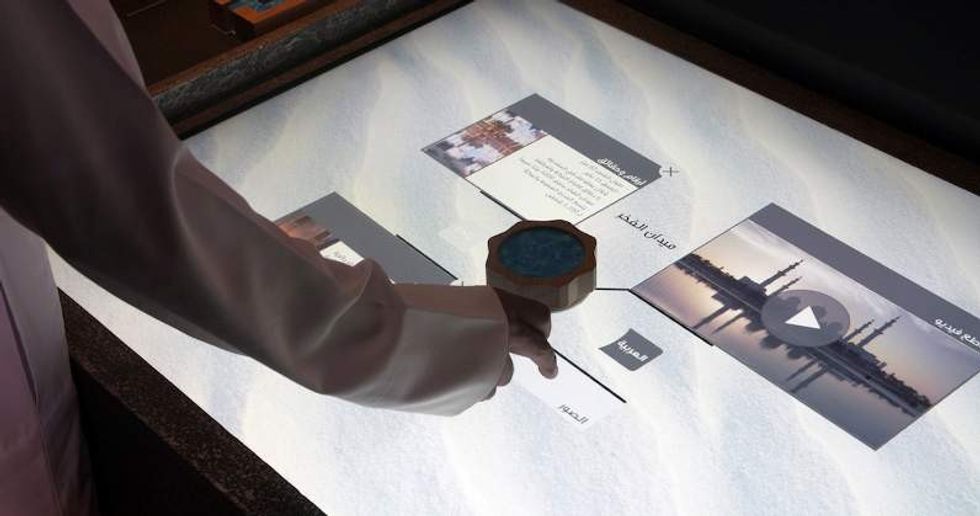 hand operating interactive medai table at Thinkwell Group's new visitor centre experience for Wahat Al Karama Memorial, Abu Dhabi