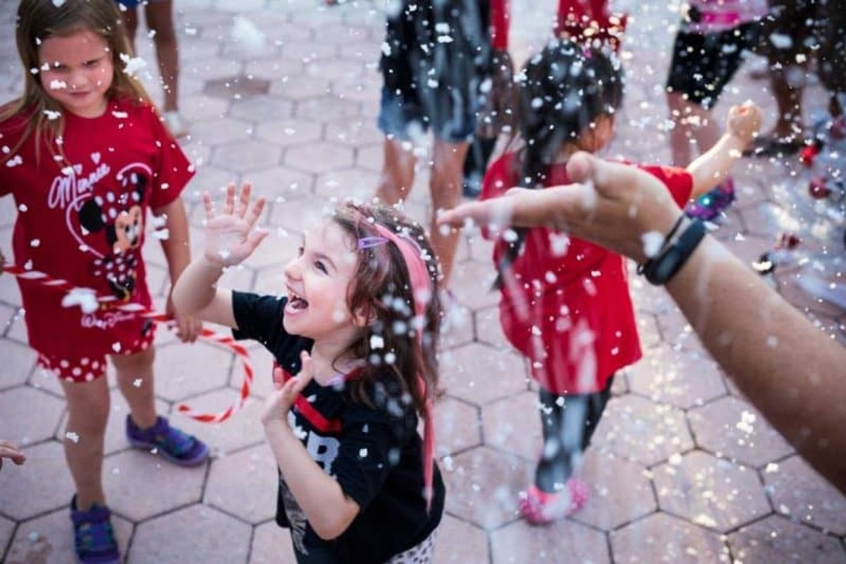 Happy children enjoying snowfall at Give Kids The World