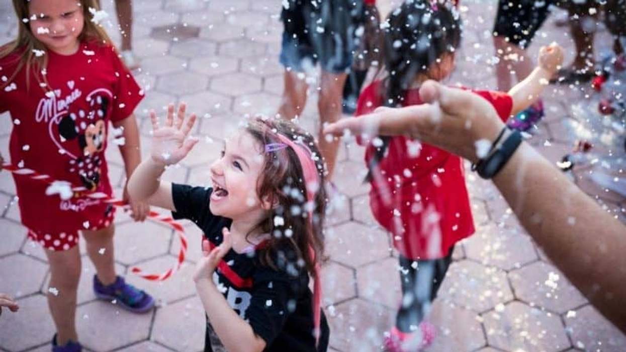 Happy children enjoying snowfall at Give Kids The World