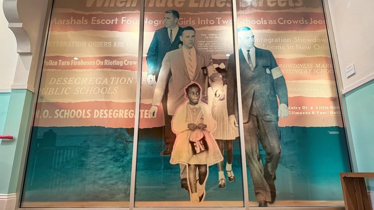 Historic photo mural of a girl escorted to school, highlighting desegregation tensions.