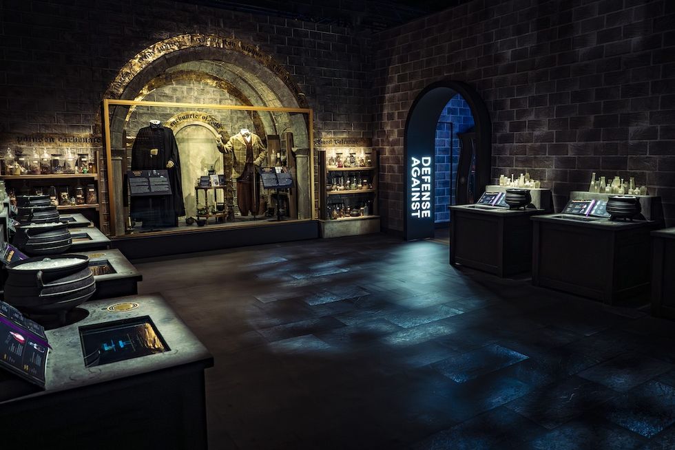 Hogwarts classroom museum exhibit with costumes and potion displays in Harry Potter: The Exhibition