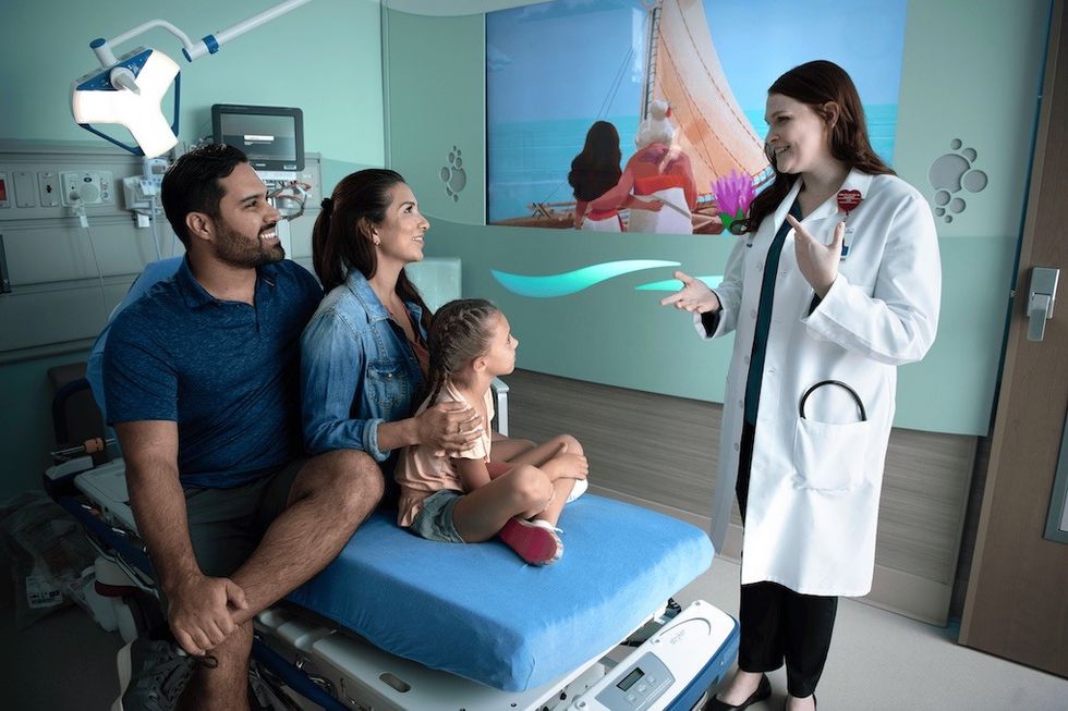 Hospital room with family, doctor and Moana wall art