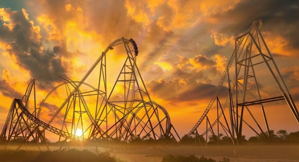 Hyperia roller coaster against a dramatic sunset with clouds and vibrant orange hues.