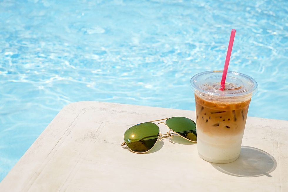 Iced coffee and sunglasses beside the pool