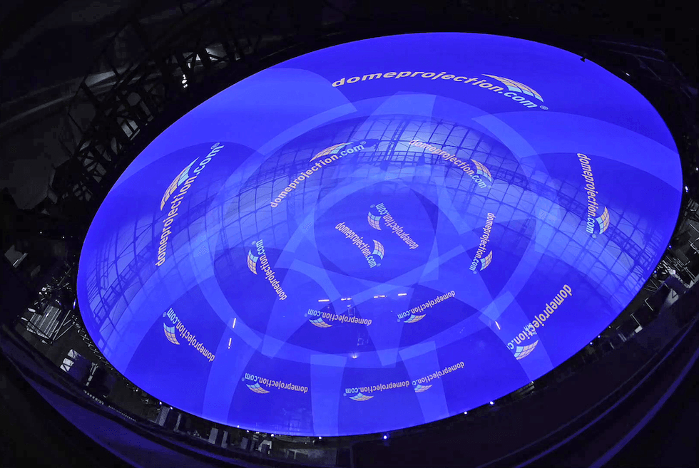 Illuminated dome with "domeprojection.com" logos, glowing in deep blue.