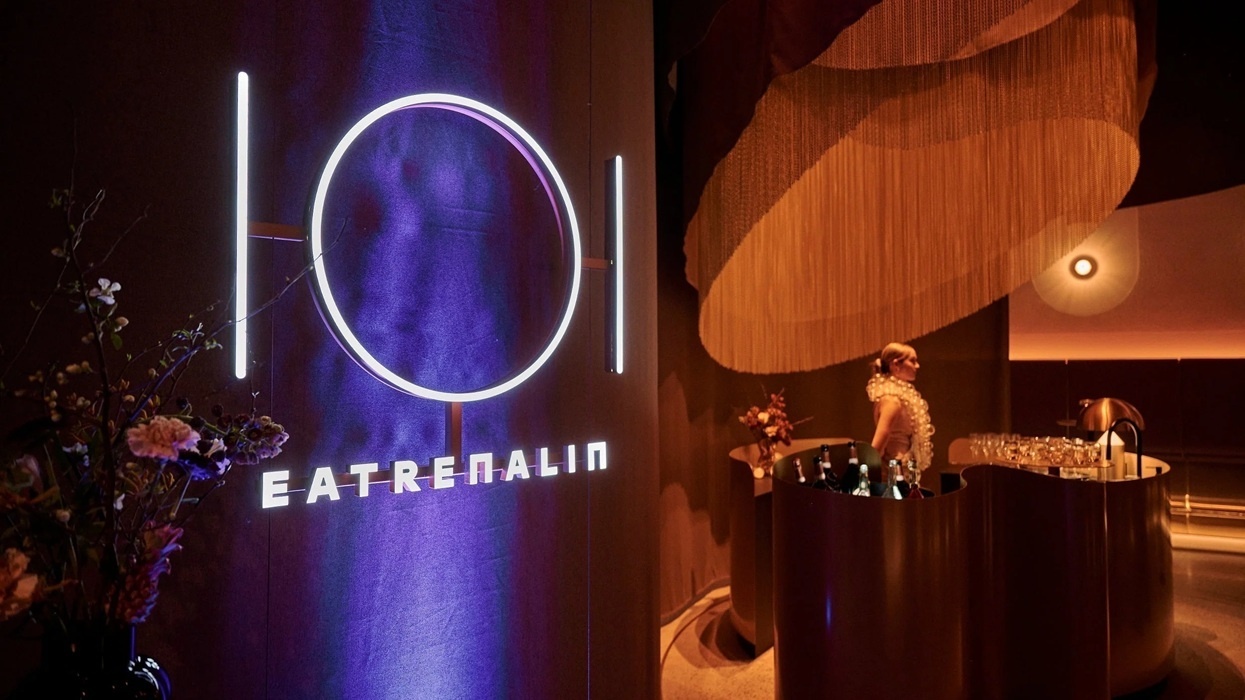Illuminated sign at Europa-Park's "Eatrenalin", with woman in elegant dress behind a bar.