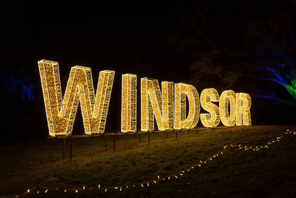 Illuminated "Windsor" sign glowing brightly at night on a grassy area.
