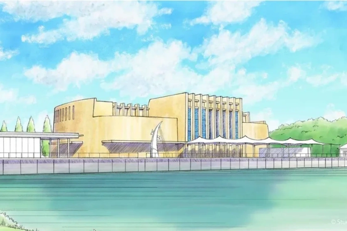 Illustrated theater building by a riverside under a bright blue sky with fluffy clouds.