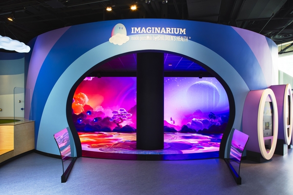 Imaginarium entrance with vibrant, colorful cosmic display and curved blue wall.
