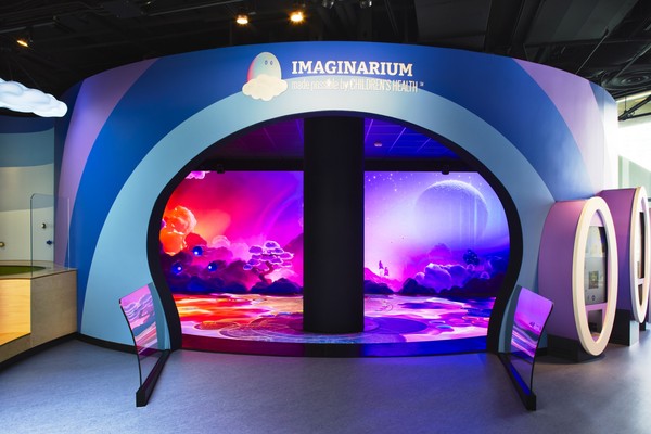 Imaginarium entrance with vibrant, colorful cosmic display and curved blue wall.