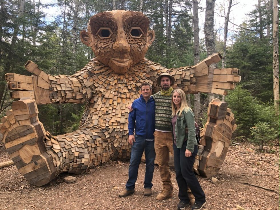 Imagine Exhibitions celebrates 15 years Tom Zaller, artist Thomas Dambo, and his wife, Alexa Dambo, in front of the giant