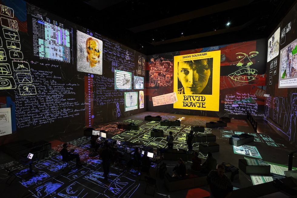 Immersive exhibit with David Bowie's art and writings projected on walls and floor.
