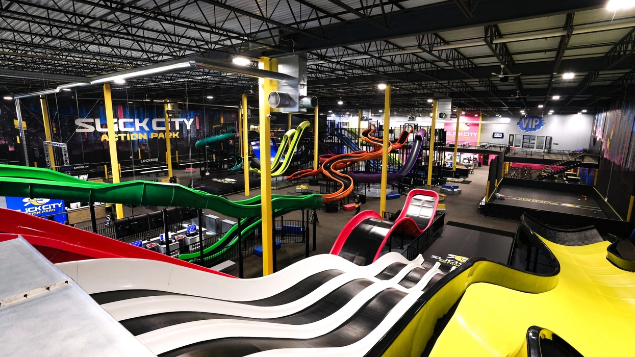 Indoor action park called Slick City with colorful slides and climbing structures.