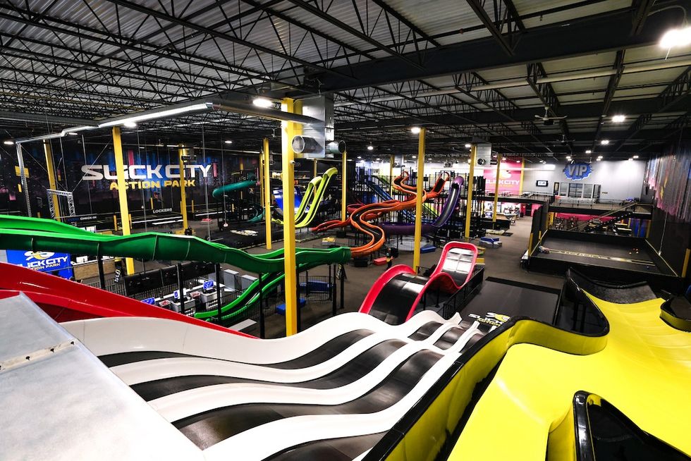 Indoor amusement park with colorful slides and play areas.