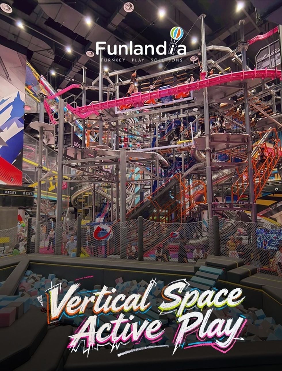 Indoor BE1ST vertical playground with slides, ropes, and climbing structures; text reads "Vertical Space Active Play."