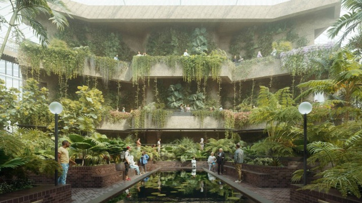 Indoor garden with lush greenery, water feature, and visitors exploring under a glass roof. Barbican Conservatory