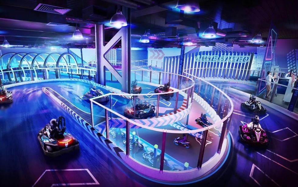 Indoor go-kart track with neon lights and multiple racers on a curved track.