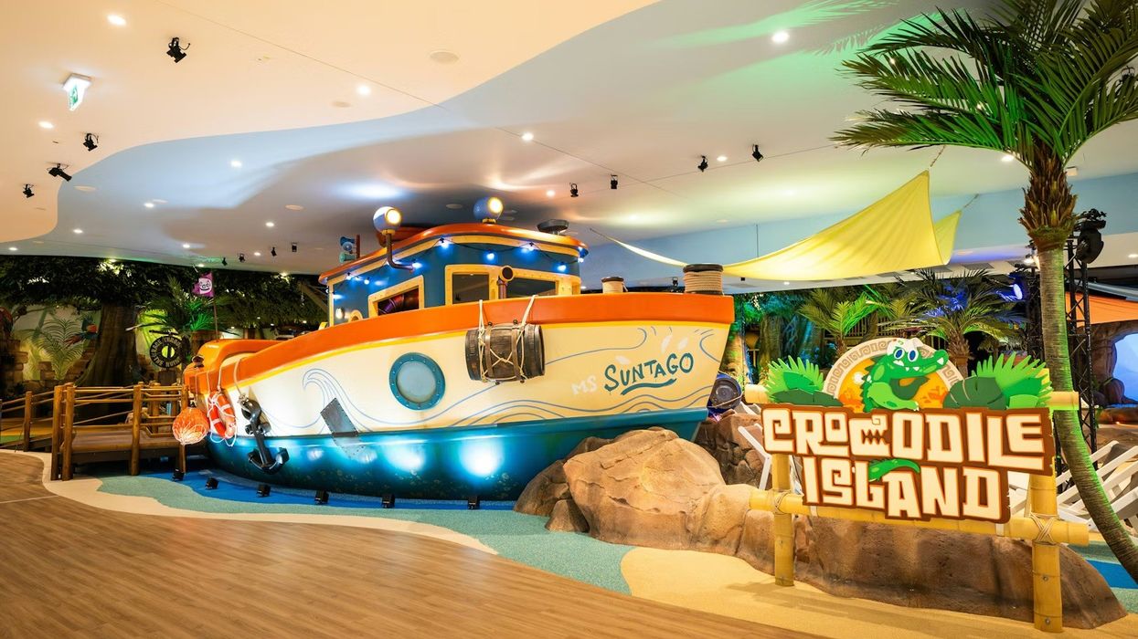 Indoor play area with a boat and "Crocodile Island" sign surrounded by tropical decor. Creative Studio Berlin