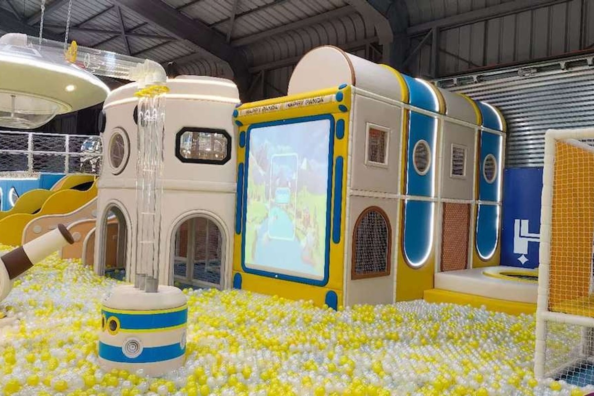 Indoor play area with colorful slides, ball pit, and spaceship-themed structures.