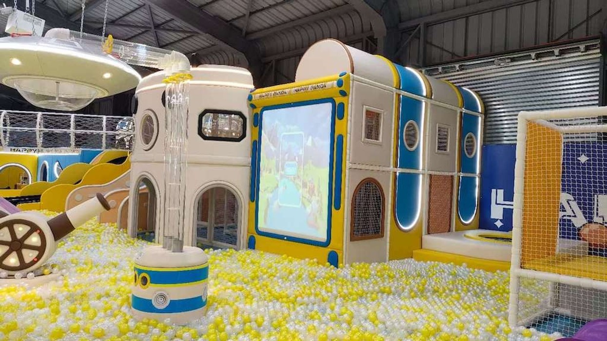 Indoor play area with colorful slides, ball pit, and spaceship-themed structures.