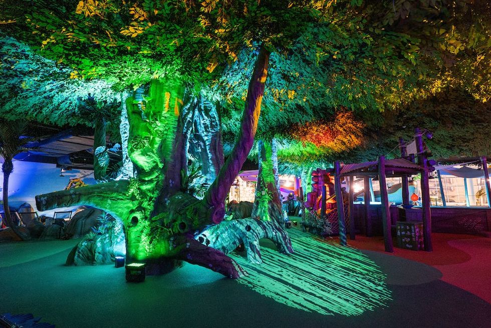 Indoor playground at Suntago Water World with large illuminated tree and colorful play structures.