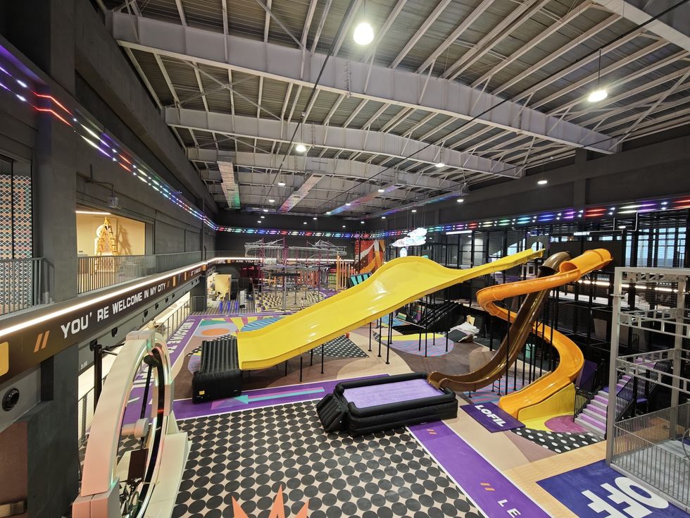 Indoor playground with colorful slides and climbing structures.