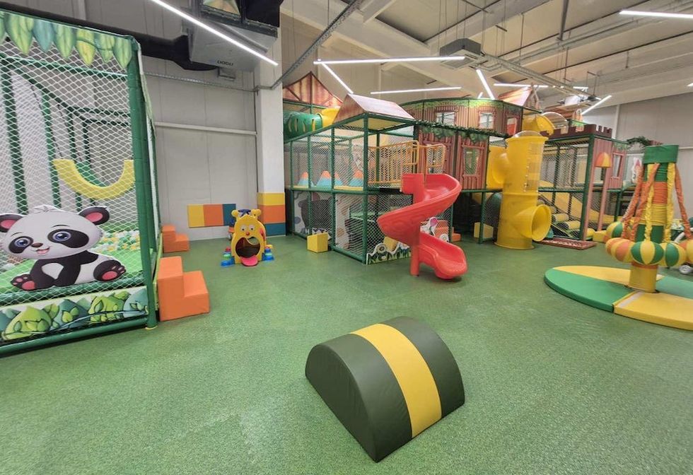Indoor playground with slides, tunnels, and colorful climbing structures.