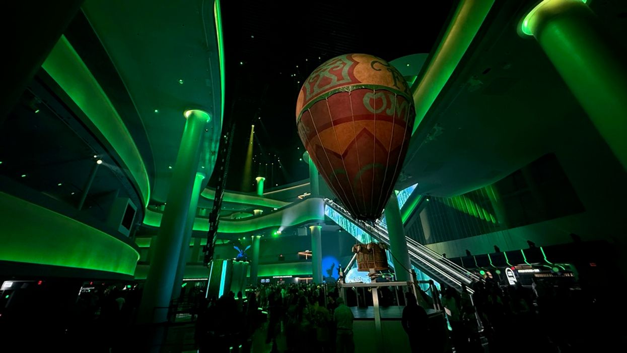 Indoor scene with a glowing green theme and a large hot air balloon display.