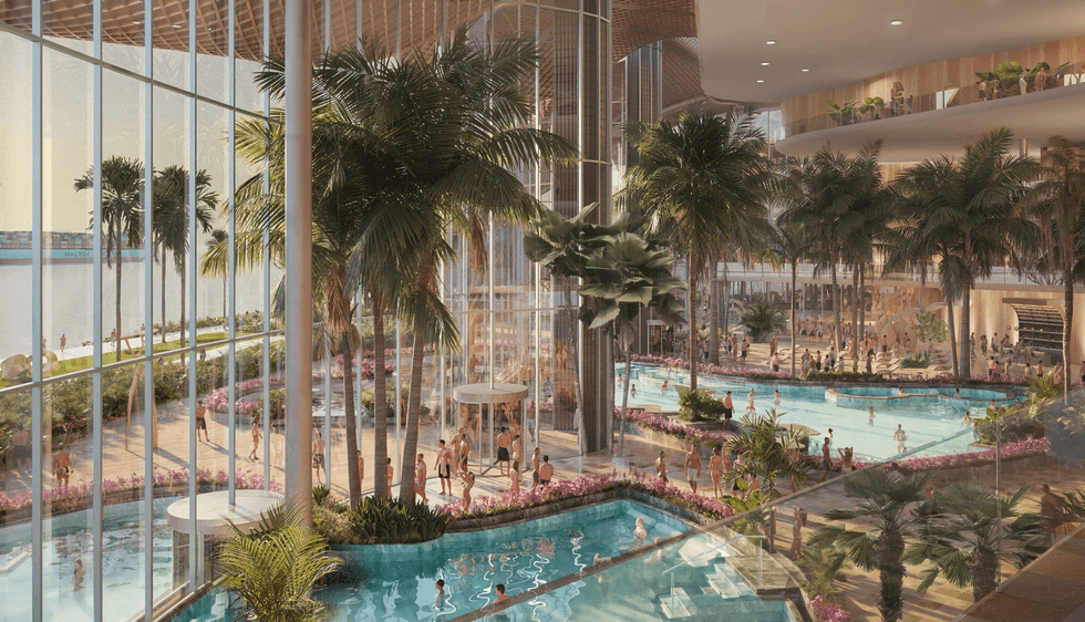 Indoor tropical pool resort called Therme Singapore with palm trees, large windows, and people swimming.