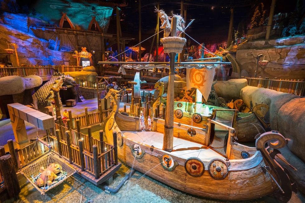 Indoor Viking-themed boat ride with colorful lighting and wooden fences.