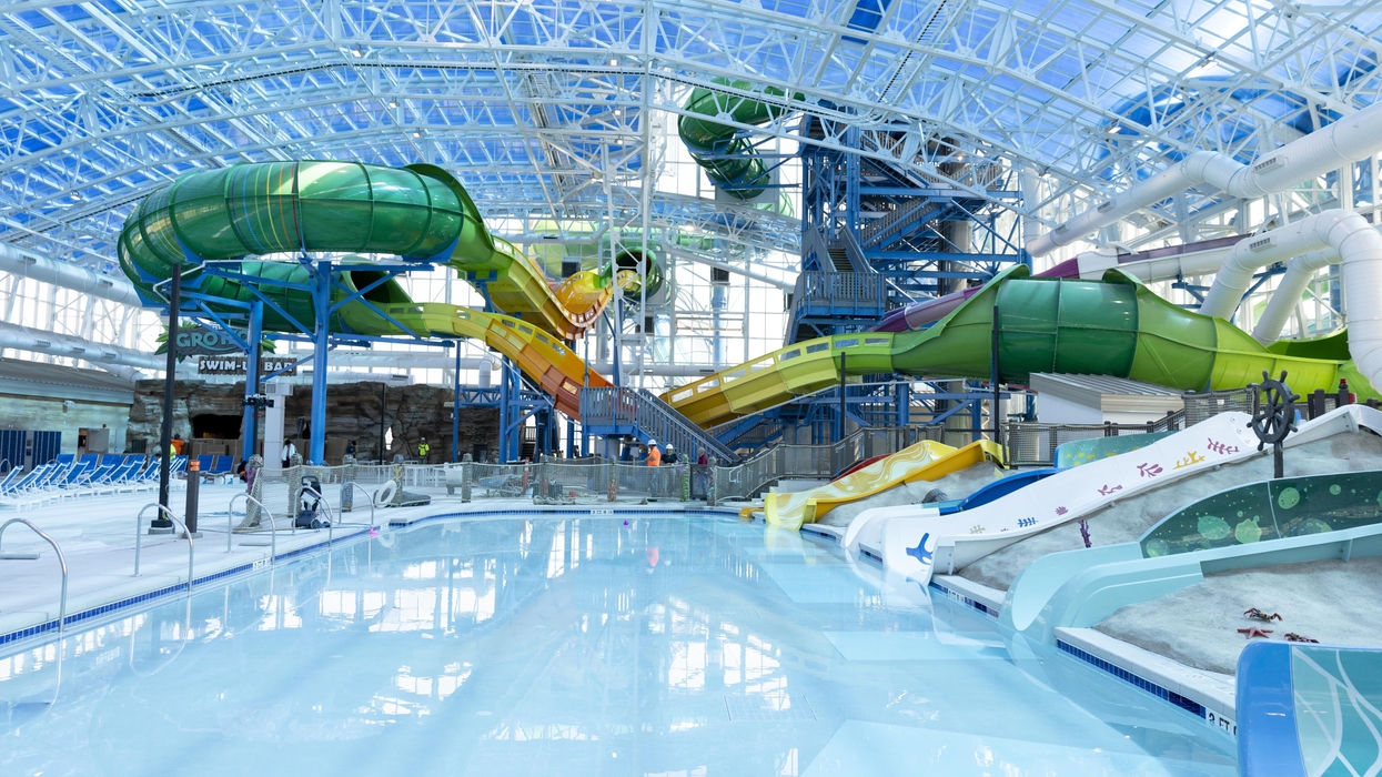 Indoor water park at Kalahari resort with twisting slides and a large pool under a blue glass ceiling.