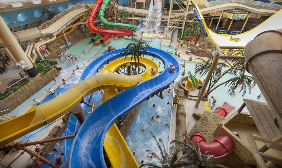 Indoor water park with colorful slides and a busy swimming pool at Sandcastle Waterpark