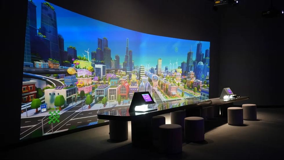 Interactive city display with futuristic buildings and control consoles at ALEM AI International Center for Artificial Intelligence