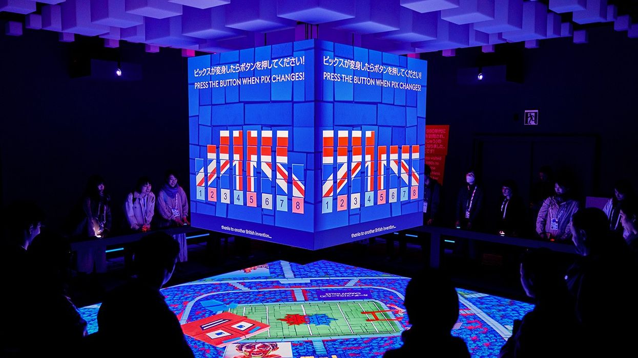 Interactive digital display in a dim room with people observing.