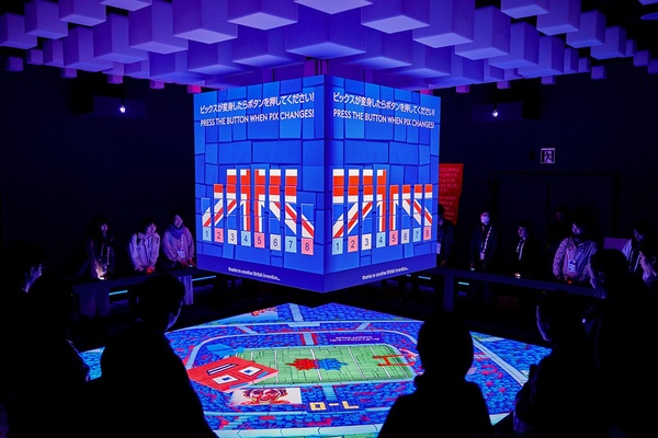 Interactive digital display in a dim room with people observing.